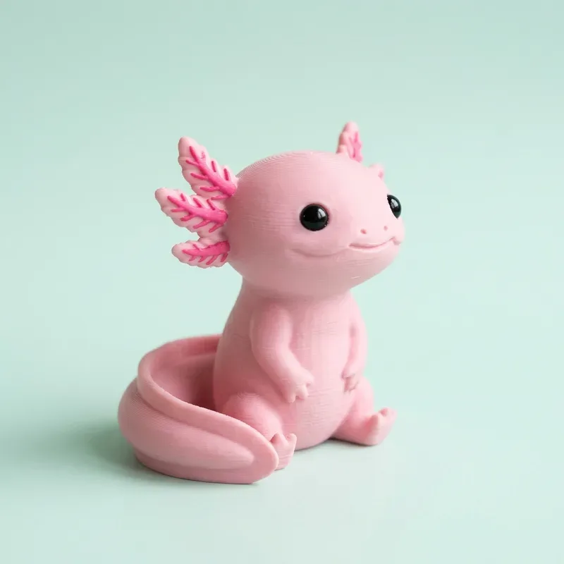 Figura de ajolote rosado sentado con branquias rosadas y ojitos negros