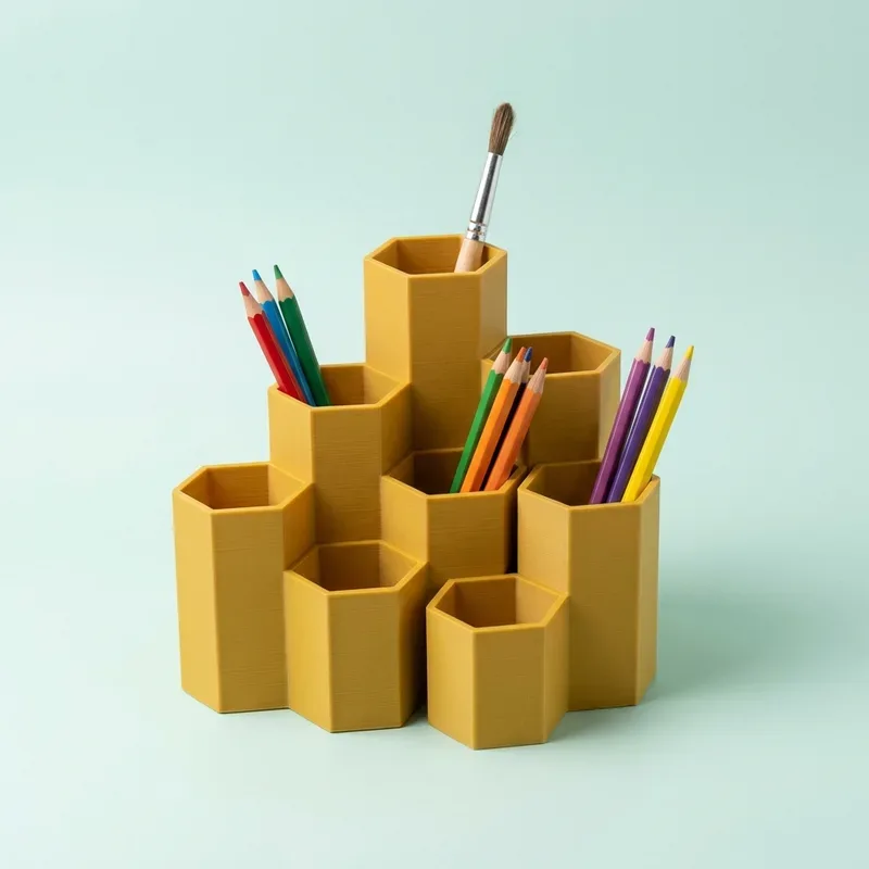 Organizador de escritorio amarillo con celdas hexagonales y lápices de colores