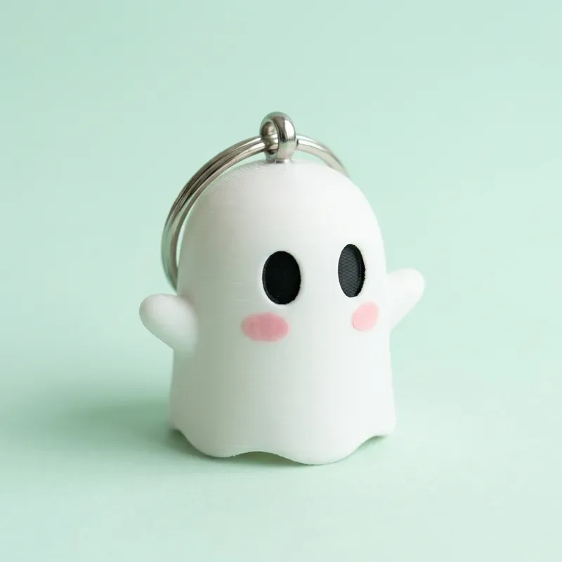 Llavero de fantasma blanco con ojos negros, mejillas rosadas y argolla metálica