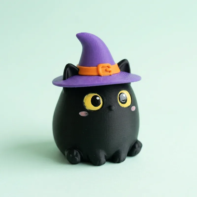 Figura de gatito negro sentado con sombrero de bruja morado y ojos amarillos